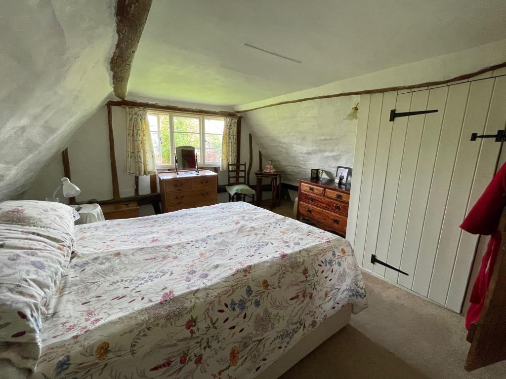 Lot: 145 - DETACHED COTTAGE IN HERTFORDSHIRE VILLAGE LOCATION - Bedroom 2 with exposed beams and window to side